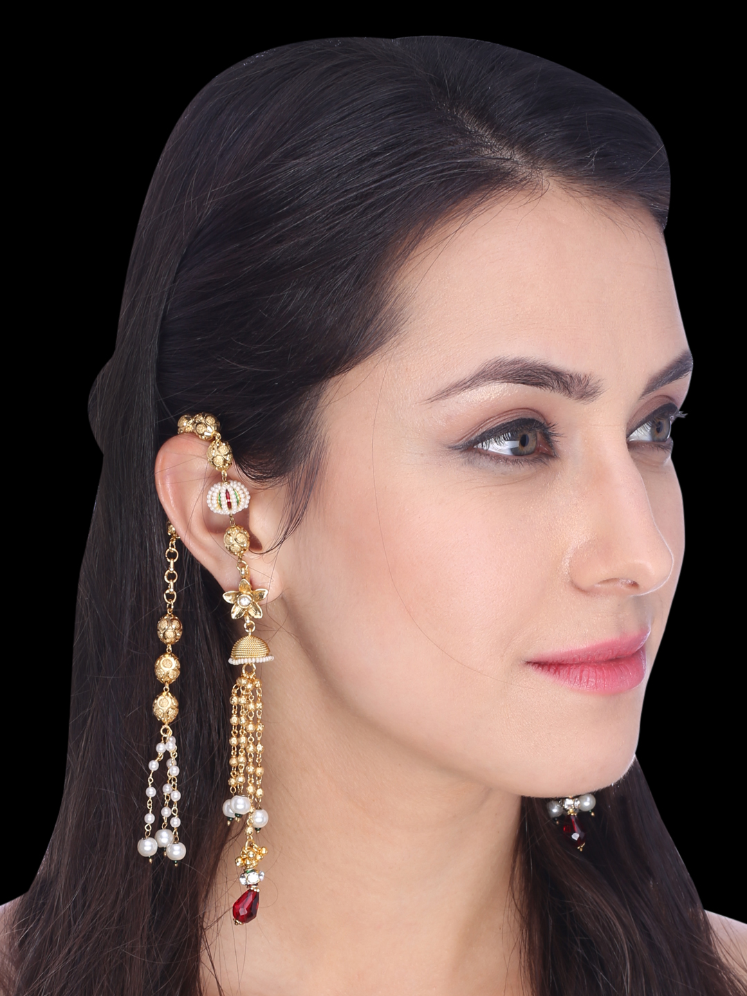 Profile of a woman with long dark hair wearing ornate gold earrings with pearls and red gems.