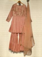 Peach-pink women's traditional suit with floral embroidery, shown with matching sheer dupatta on a hanger.